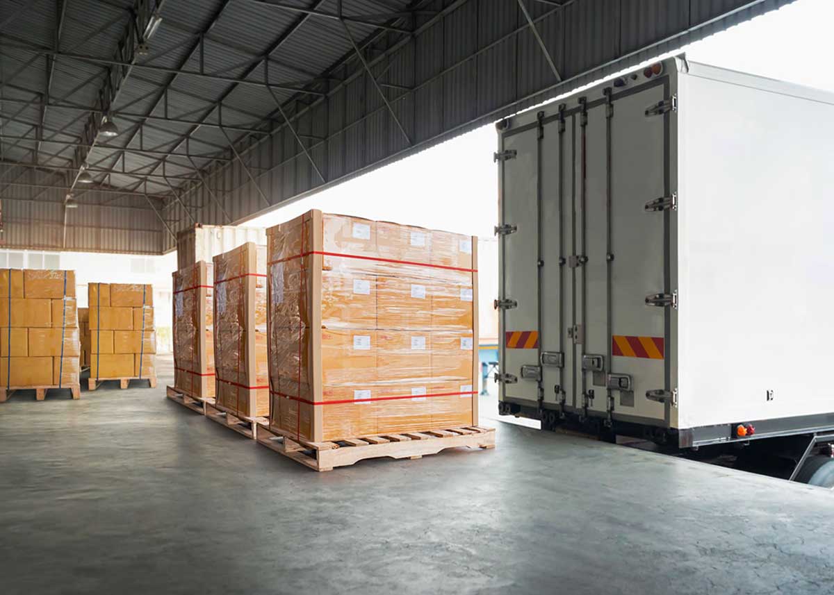 Operazioni di carico di un container presso un magazzino di stoccaggio merci