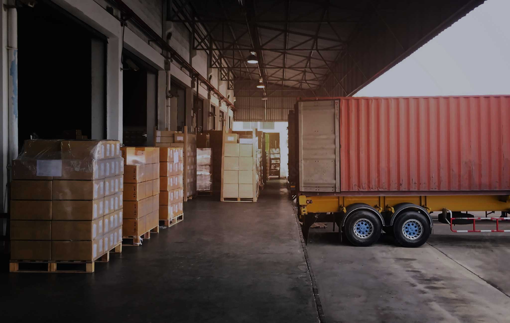 Operazioni di carico di un container presso un magazzino di stoccaggio merci